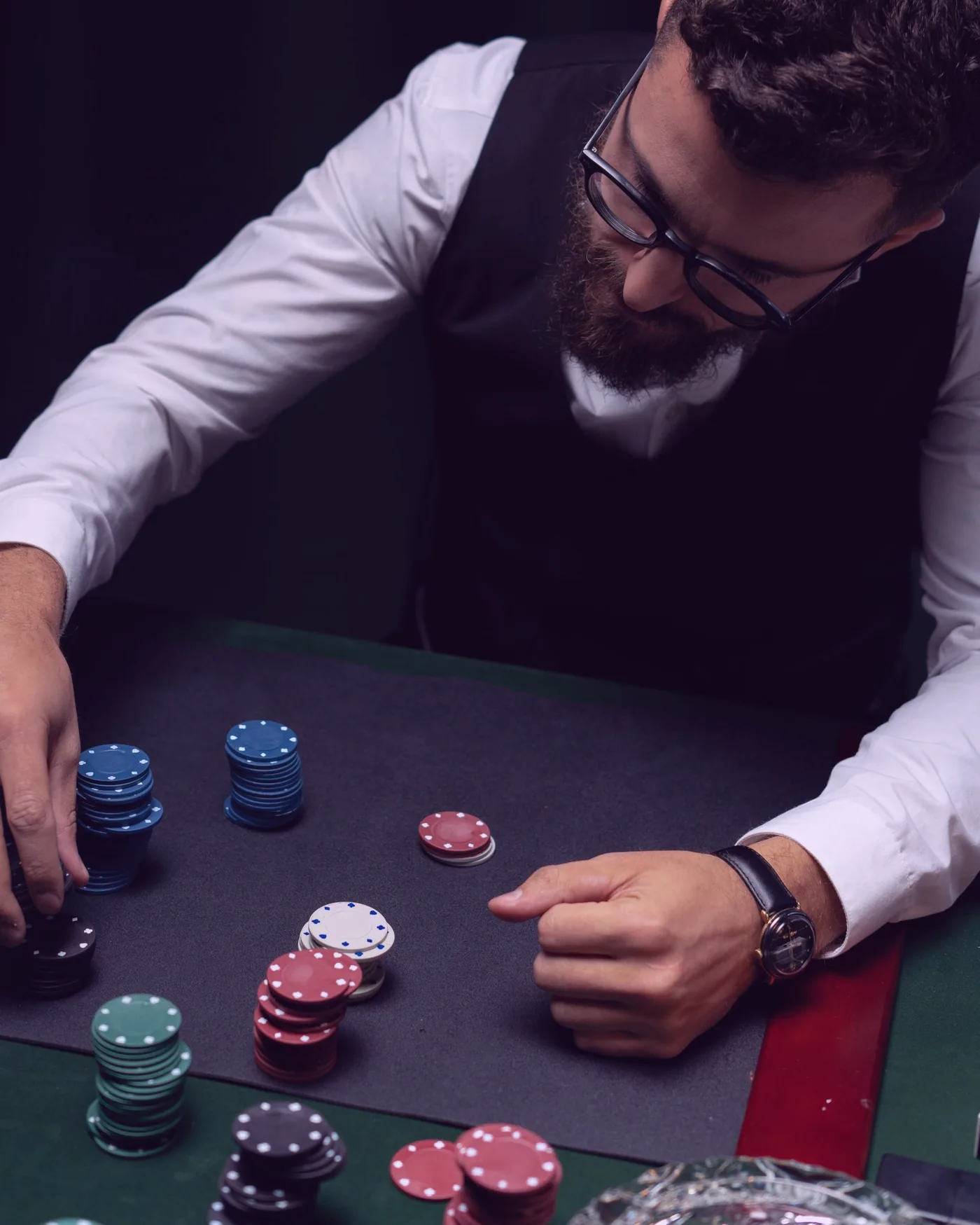 A hand pausing mid-roll with a pair of dice over the table