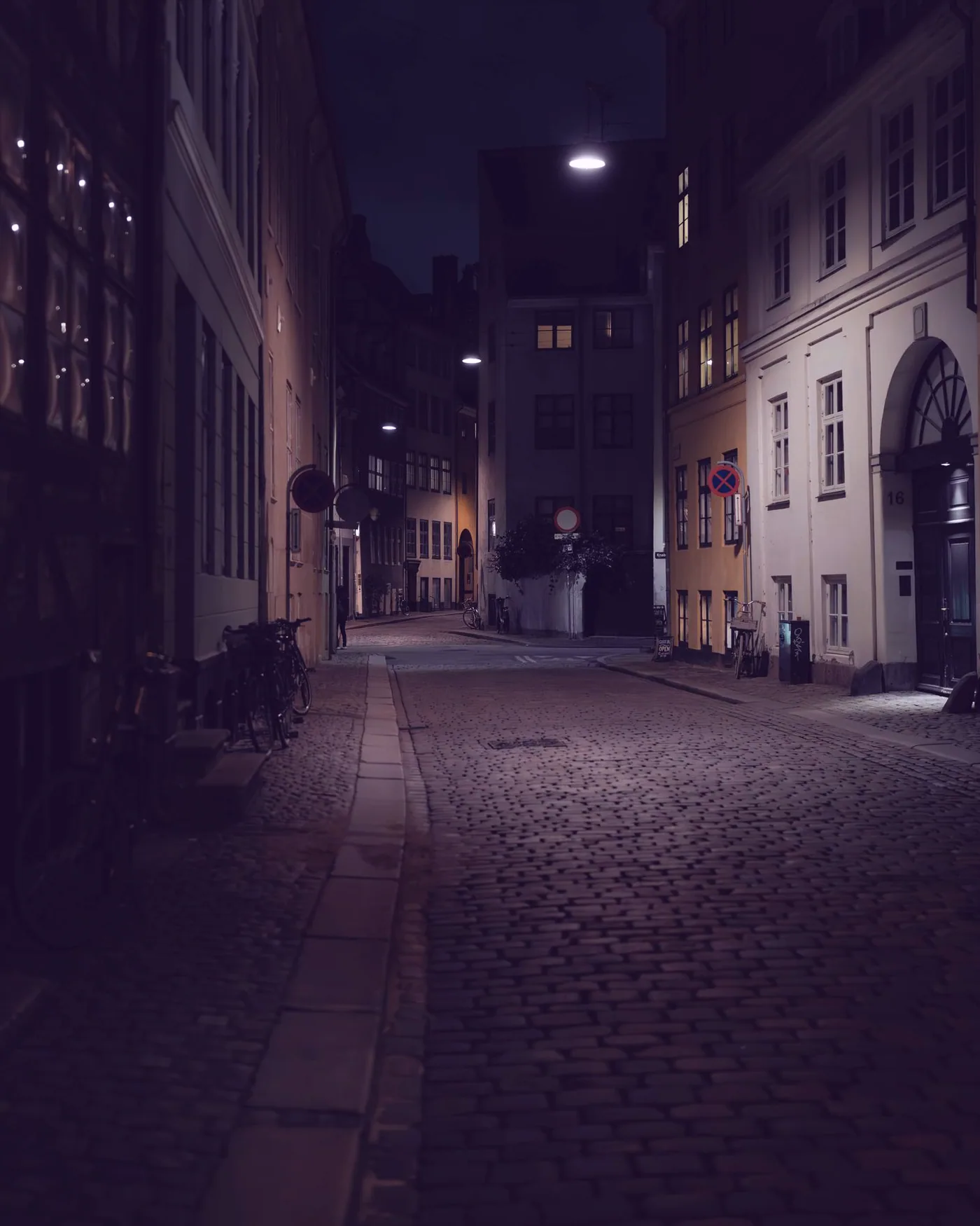 The street outside, cobbles and lamplight after dark